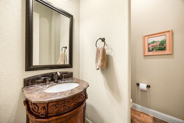 bathroom featuring vanity, toilet, and baseboards