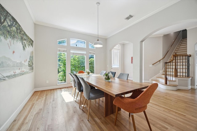 4005 Gramercy St, Houston, TX 77025 - dining area featuring arched walkways, ornamental molding, stairway, light wood-style flooring, and baseboards