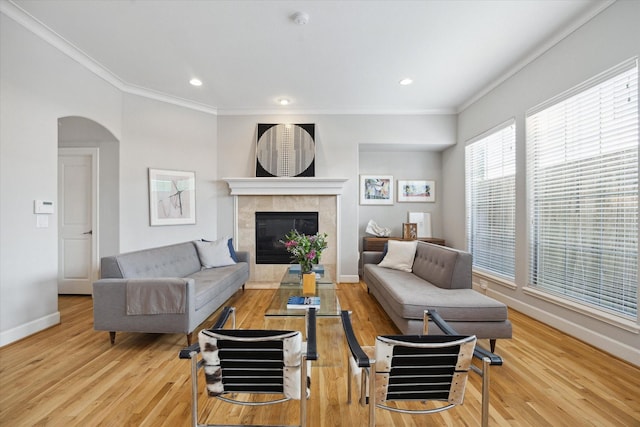 4005 Gramercy St, Houston, TX 77025 - living room featuring ornamental molding, baseboards, wood finished floors, a fireplace, and arched walkways