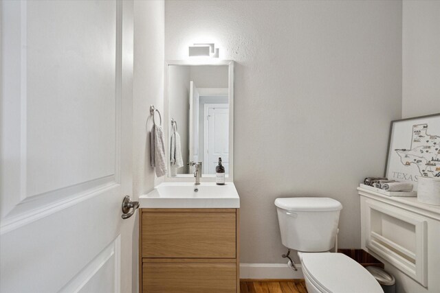 4005 Gramercy St, Houston, TX 77025 - half bathroom featuring toilet, vanity, and wood finished floors