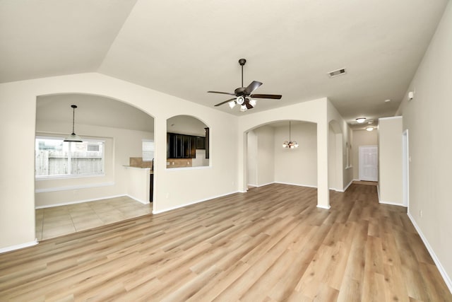 2614 Leopard Ct, Katy, TX 77449 - unfurnished living room with light wood-style flooring, ceiling fan, arched walkways, vaulted ceiling, and baseboards