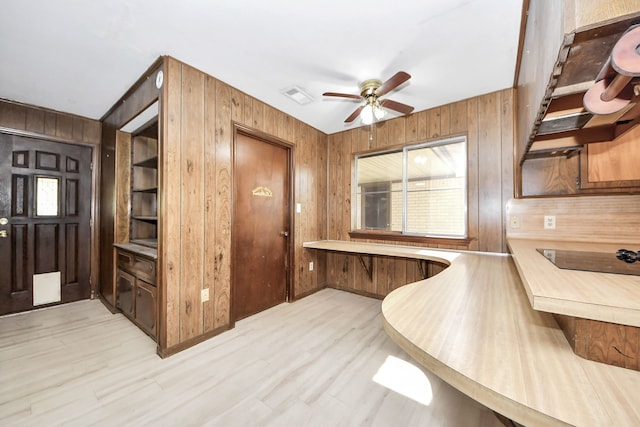 1417 Brigance Rd, Brazoria, TX 77422 - kitchen featuring wood walls, ceiling fan, light wood-style floors, and light countertops