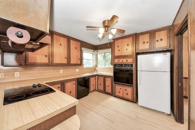 1417 Brigance Rd, Brazoria, TX 77422 - kitchen featuring black appliances, light countertops, a sink, a ceiling fan, and exhaust hood