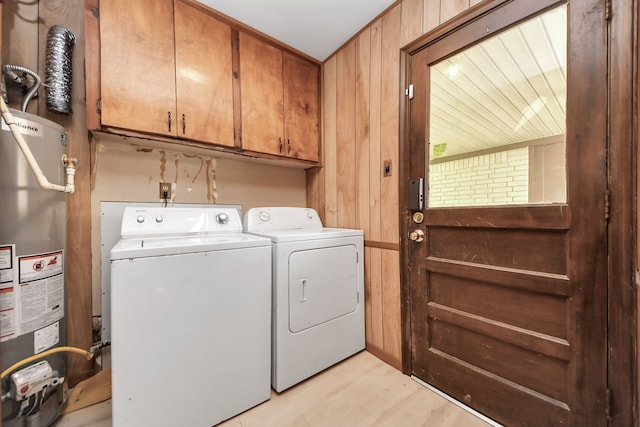 1417 Brigance Rd, Brazoria, TX 77422 - laundry area featuring water heater, cabinet space, washer and dryer, wood walls, and light wood finished floors