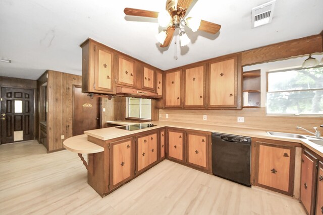 1417 Brigance Rd, Brazoria, TX 77422 - kitchen featuring black appliances, a peninsula, a sink, light countertops, and light wood-style floors