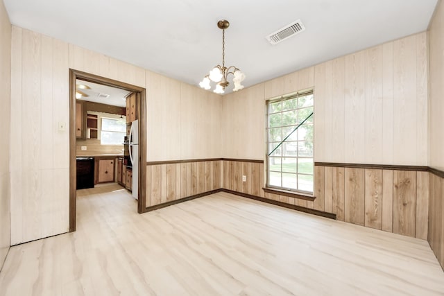 1417 Brigance Rd, Brazoria, TX 77422 - spare room with a chandelier, wooden walls, and light wood-style floors