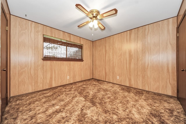 1417 Brigance Rd, Brazoria, TX 77422 - spare room featuring carpet flooring, ceiling fan, and wood walls