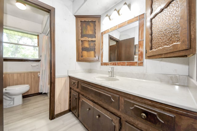 1417 Brigance Rd, Brazoria, TX 77422 - full bathroom with toilet, vanity, a wainscoted wall, curtained shower, and wood finished floors