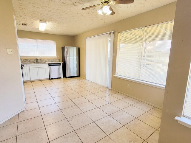 23930 Griffin House Ln, Katy, TX 77493 - kitchen with appliances with stainless steel finishes, light tile patterned floors, a ceiling fan, white cabinetry, and a sink