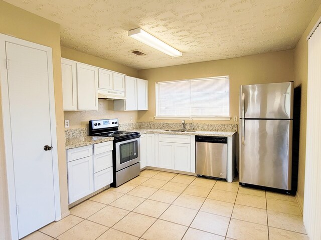 23930 Griffin House Ln, Katy, TX 77493 - kitchen featuring stainless steel appliances, a sink, under cabinet range hood, white cabinets, and a textured ceiling