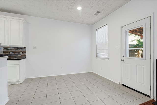 16106 Greenport Ln, Houston, TX 77084 - unfurnished dining area featuring a textured ceiling, baseboards, recessed lighting, and light tile patterned floors
