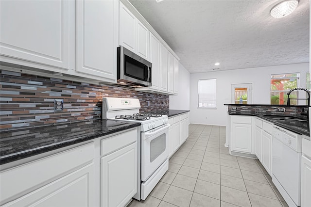 16106 Greenport Ln, Houston, TX 77084 - kitchen with white appliances, a sink, light tile patterned floors, decorative backsplash, and a textured ceiling