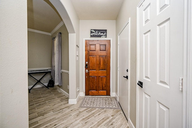 14720 Branchwest Dr, Houston, TX 77082 - entryway with arched walkways, baseboards, light wood-style floors, and crown molding