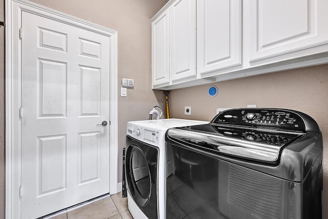 8303 Crescent Knolls Dr, Richmond, TX 77406 - washroom with light tile patterned floors, cabinet space, washer and clothes dryer, and a textured wall