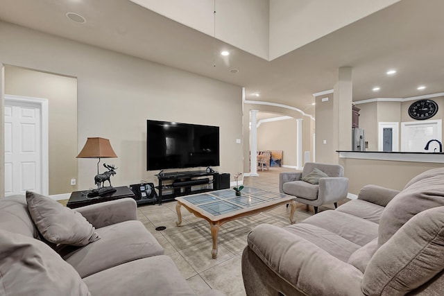 8303 Crescent Knolls Dr, Richmond, TX 77406 - living area featuring arched walkways, decorative columns, recessed lighting, light tile patterned flooring, and baseboards