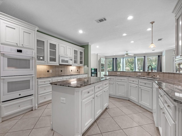 3311 El Dorado Blvd, Missouri City, TX 77459 - kitchen with white appliances, a sink, backsplash, white cabinets, and light tile patterned flooring