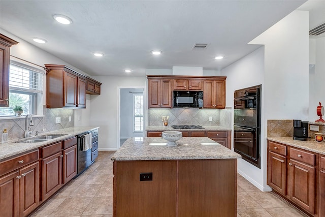 6722 Hawkins St, Manvel, TX 77578 - kitchen with a sink, black appliances, tasteful backsplash, light stone counters, and a kitchen island