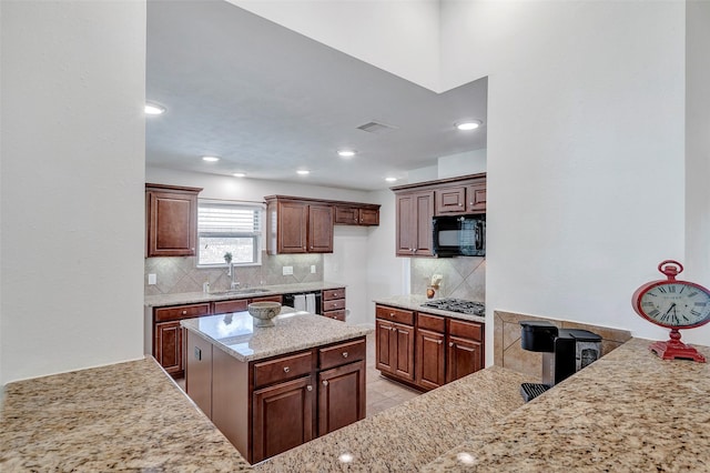 6722 Hawkins St, Manvel, TX 77578 - kitchen featuring stainless steel appliances, a sink, decorative backsplash, light stone counters, and light tile patterned floors