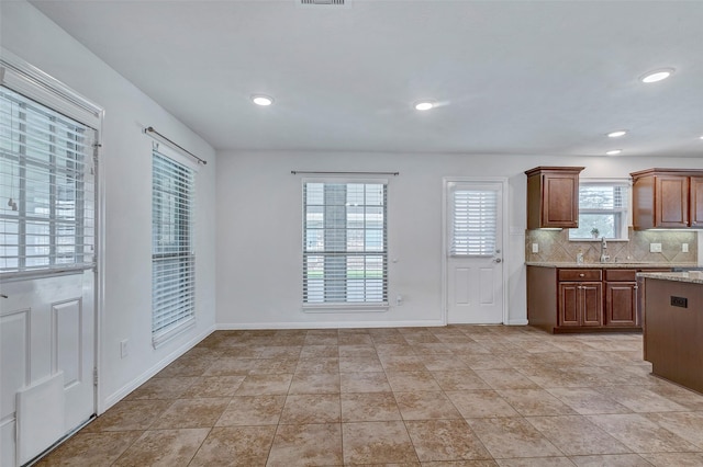 6722 Hawkins St, Manvel, TX 77578 - kitchen featuring decorative backsplash, recessed lighting, light stone counters, baseboards, and a sink