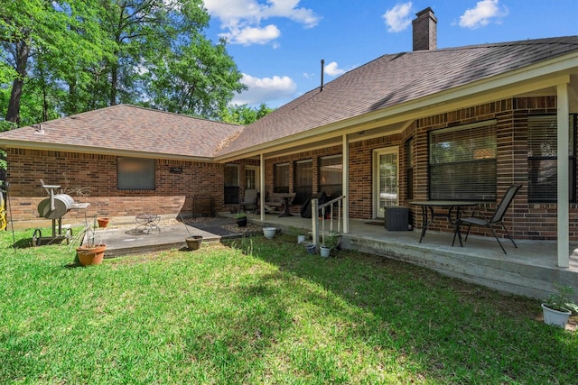 44 Westchester Dr, Conroe, TX 77304 - back of property with brick siding, a lawn, and a patio