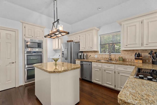 44 Westchester Dr, Conroe, TX 77304 - kitchen with appliances with stainless steel finishes, light stone counters, a kitchen island, a sink, and dark wood-style flooring