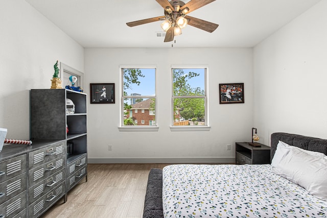 bedroom featuring light wood-style flooring, baseboards, and a ceiling fan