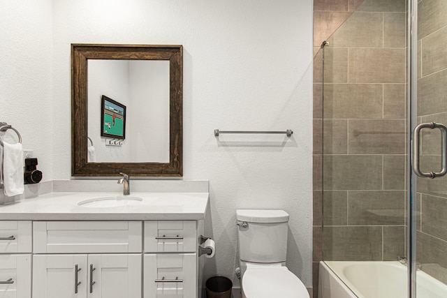 bathroom with vanity, toilet, and shower / bath combination with glass door