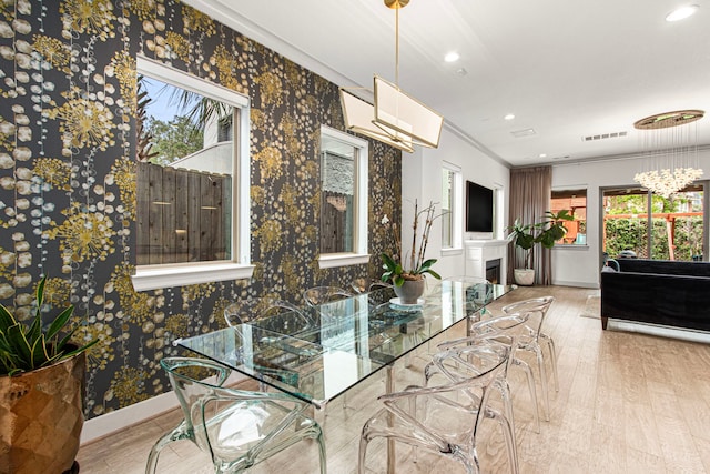 dining room with baseboards, wood finished floors, recessed lighting, crown molding, and wallpapered walls