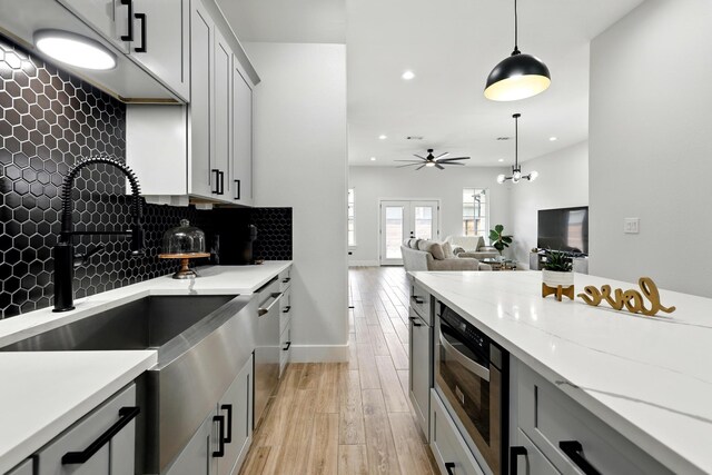 5209 Canal St, Houston, TX 77011 - kitchen featuring a sink, recessed lighting, light wood-type flooring, backsplash, and gray cabinetry