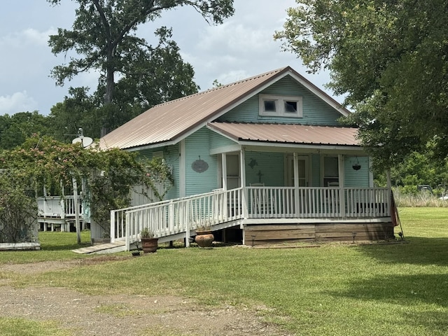 12215 Fm 442nd Rd, Boling, TX 77420 - view of front facade featuring covered porch, a front yard, and metal roof