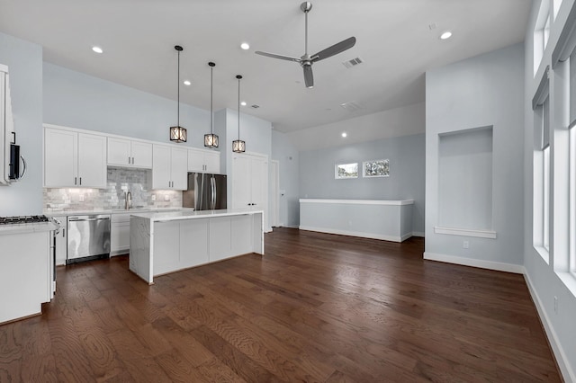 804 Woodcrest Dr Unit F, Houston, TX 77018 - kitchen featuring appliances with stainless steel finishes, a kitchen island, a ceiling fan, tasteful backsplash, and light countertops