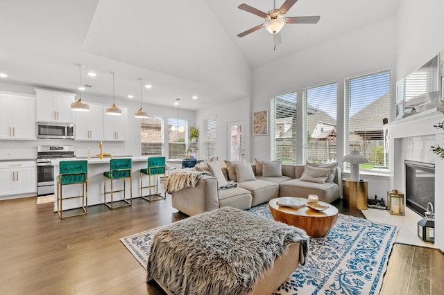 2824 Jehlon Ln, Conroe, TX 77385 - living area with wood finished floors, a ceiling fan, high vaulted ceiling, recessed lighting, and a fireplace