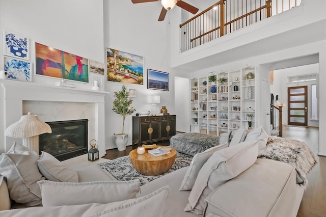 2824 Jehlon Ln, Conroe, TX 77385 - living area featuring a high ceiling, wood finished floors, ceiling fan, a high end fireplace, and stairs