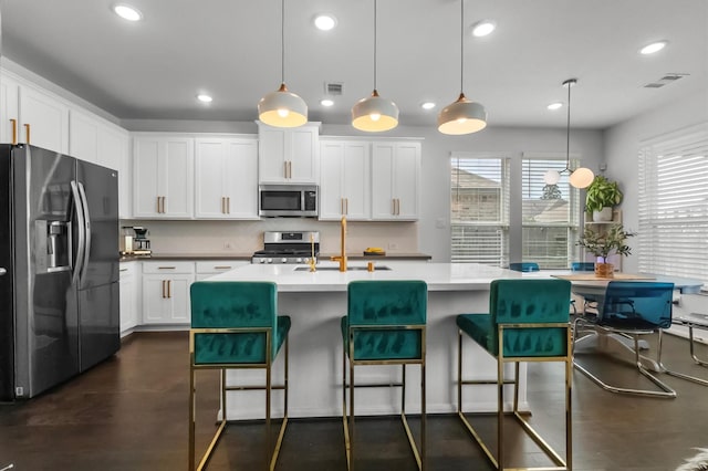 2824 Jehlon Ln, Conroe, TX 77385 - kitchen with appliances with stainless steel finishes, recessed lighting, a sink, white cabinetry, and a breakfast bar area