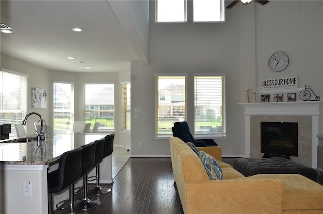 living room featuring healthy amount of natural light, ceiling fan, a fireplace, and recessed lighting
