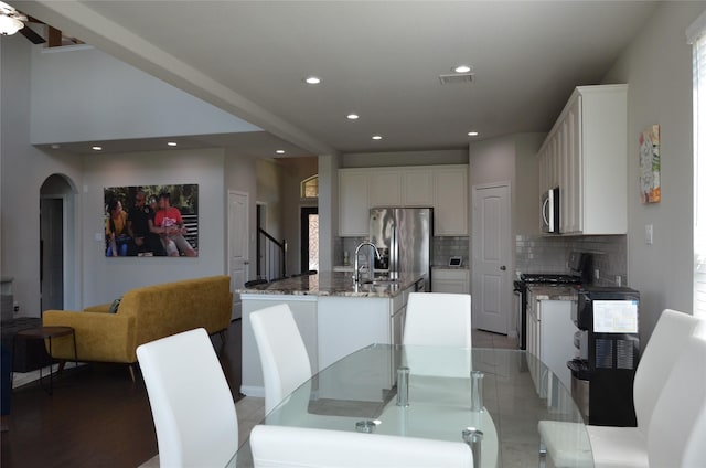 dining space with recessed lighting, arched walkways, and a ceiling fan