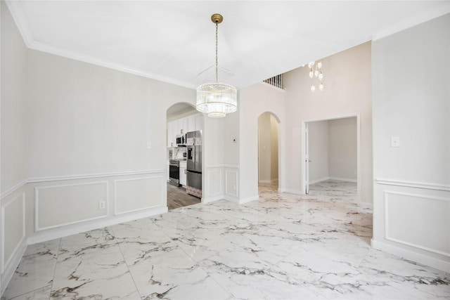 1910 Shark Ct, Crosby, TX 77532 - unfurnished dining area featuring arched walkways, a chandelier, a decorative wall, wainscoting, and light marble finish floors