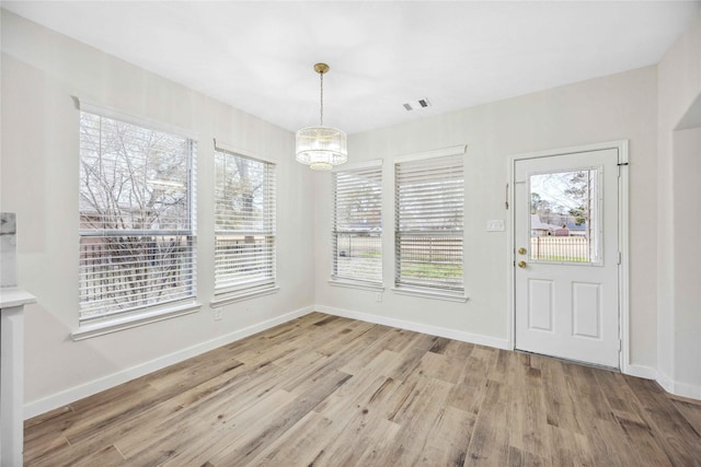 1910 Shark Ct, Crosby, TX 77532 - unfurnished dining area with a chandelier, wood finished floors, and baseboards