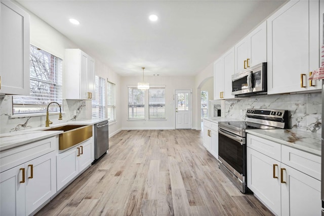 1910 Shark Ct, Crosby, TX 77532 - kitchen with stainless steel appliances, a sink, tasteful backsplash, white cabinetry, and recessed lighting