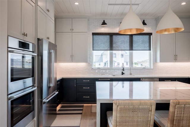 1311 Oahu Dr, Tiki Island, TX 77554 - kitchen featuring a sink, stainless steel appliances, tasteful backsplash, a breakfast bar, and wooden ceiling