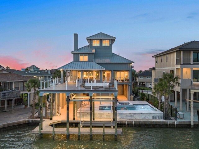 1311 Oahu Dr, Tiki Island, TX 77554 - rear view of property with a water view, a standing seam roof, metal roof, stairs, and a chimney