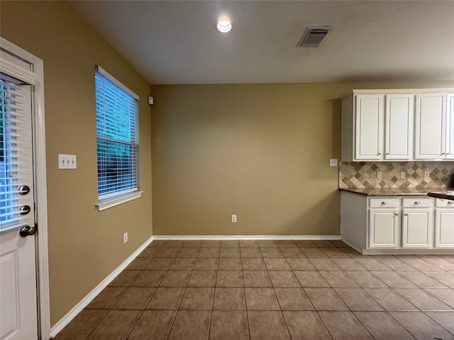 118 N Camellia Grove Cir, The Woodlands, TX 77382 - kitchen with tile patterned flooring, decorative backsplash, white cabinets, and baseboards