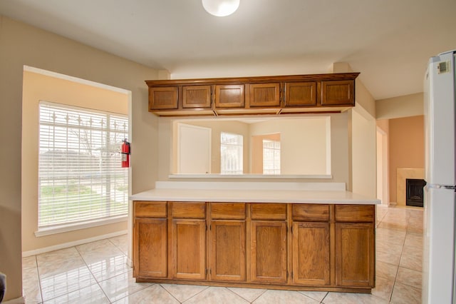 9470 Gulf Bridge St, Houston, TX 77075 - kitchen with freestanding refrigerator, brown cabinets, light countertops, and a fireplace