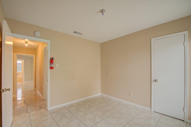 9470 Gulf Bridge St, Houston, TX 77075 - empty room featuring fire sprinkler in ceiling, light tile patterned floors, a smoke detector, and baseboards