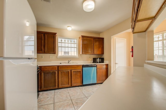 9470 Gulf Bridge St, Houston, TX 77075 - kitchen featuring freestanding refrigerator, dishwashing machine, light tile patterned floors, black microwave, and light countertops
