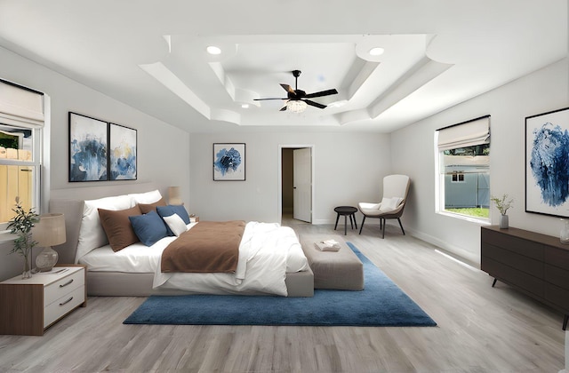 5614 Northridge Dr, Houston, TX 77033 - bedroom featuring light wood-style floors, a tray ceiling, ceiling fan, and baseboards