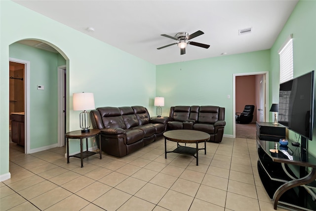 11020 Panther Ct, Houston, TX 77099 - living room with a ceiling fan, arched walkways, light tile patterned flooring, and baseboards