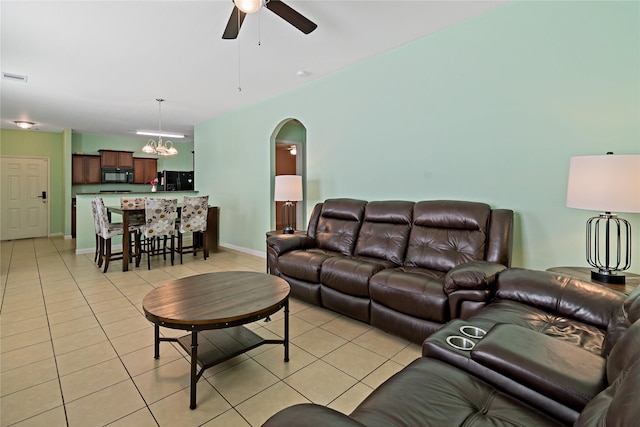 11020 Panther Ct, Houston, TX 77099 - living room featuring light tile patterned floors, ceiling fan, a chandelier, arched walkways, and baseboards