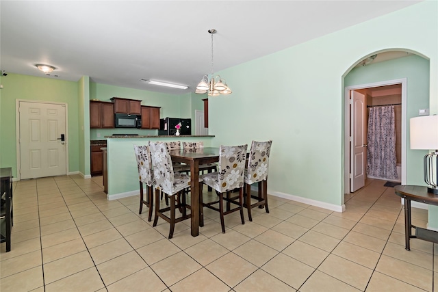11020 Panther Ct, Houston, TX 77099 - dining space with a chandelier, light tile patterned floors, arched walkways, and baseboards