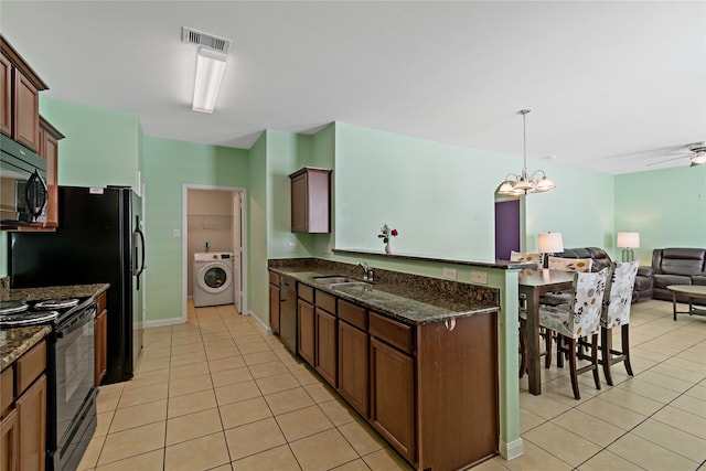 11020 Panther Ct, Houston, TX 77099 - kitchen with washer / dryer, black appliances, light tile patterned floors, open floor plan, and a sink
